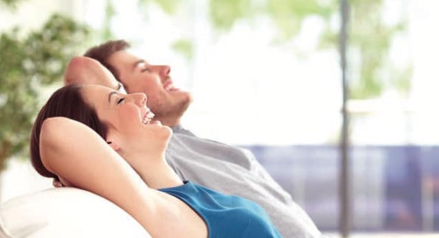 A young couple relaxing on a couch.