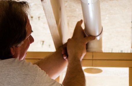 A plumber installing a pipe.