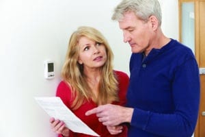 A couple looking at their reduced utility bill.