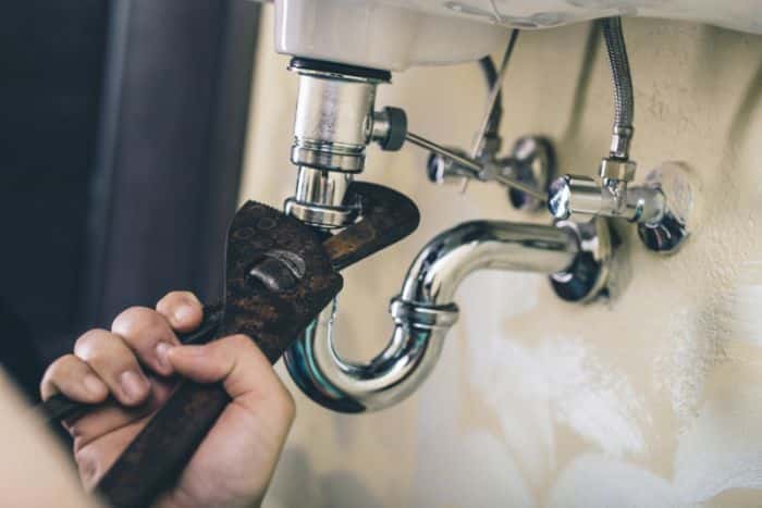 Trying to fix sink drain with pipe wrench.