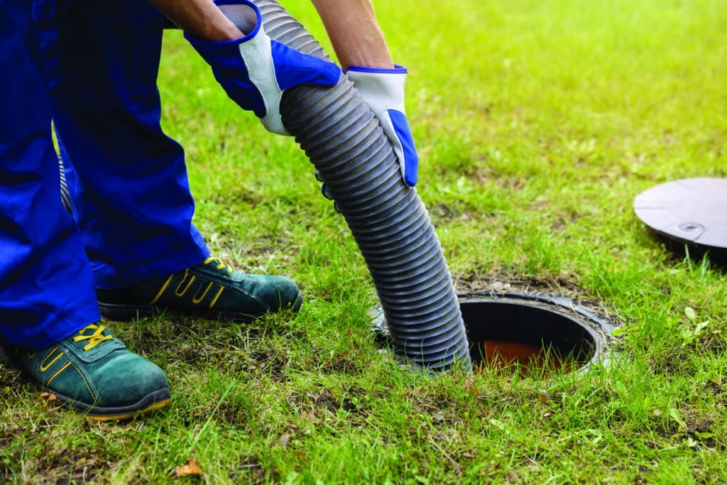 A man pumps out a household septic tank